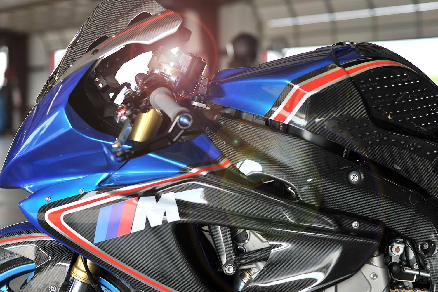 Close side view of a blue race bike with carbon fiber body panels
