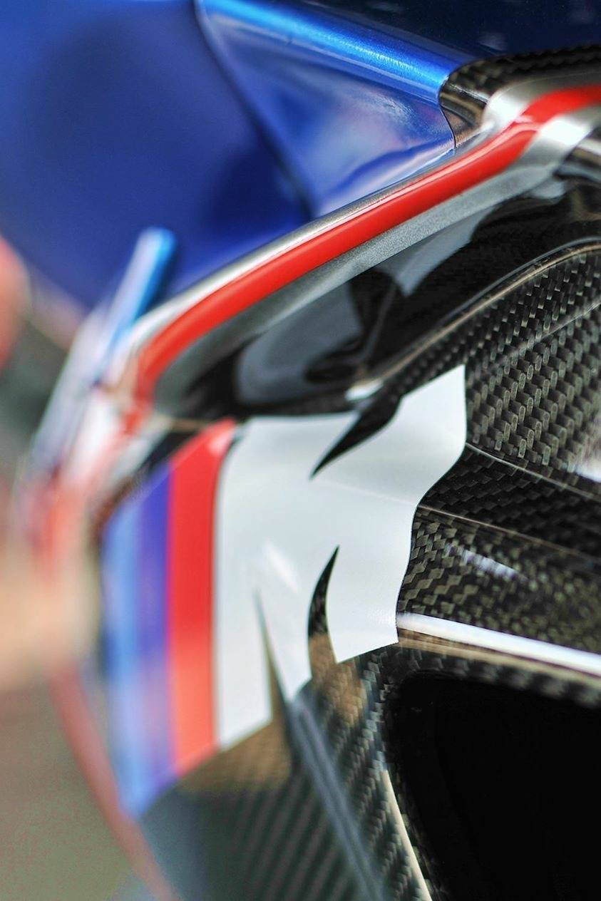Close-up of a carbon fiber race bike fairing with M livery